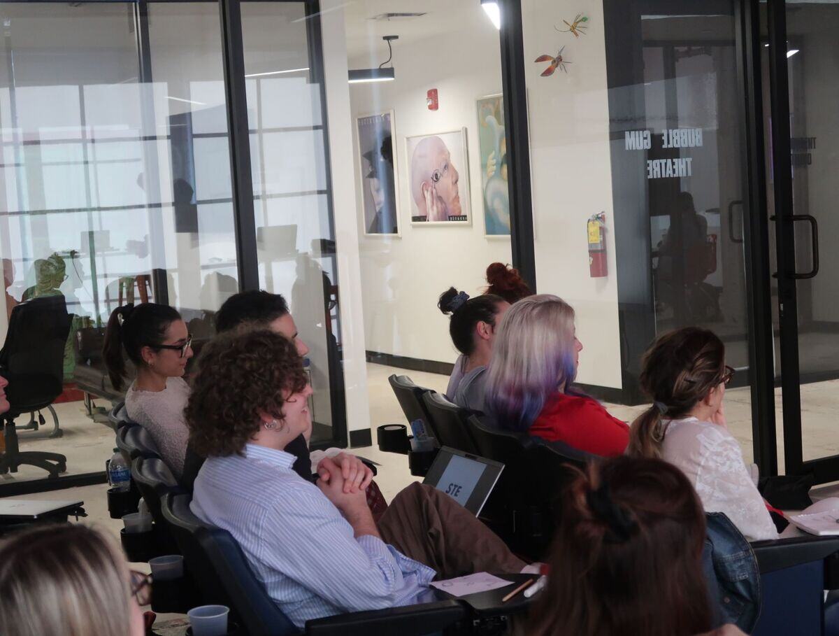 A diverse group of individuals sitting in a conference room, engaged in a meeting.